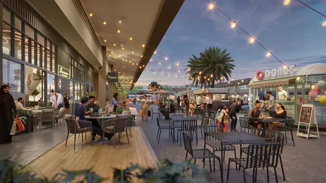 Diners at the A-SOHO food truck park under festoon lighting at dusk.