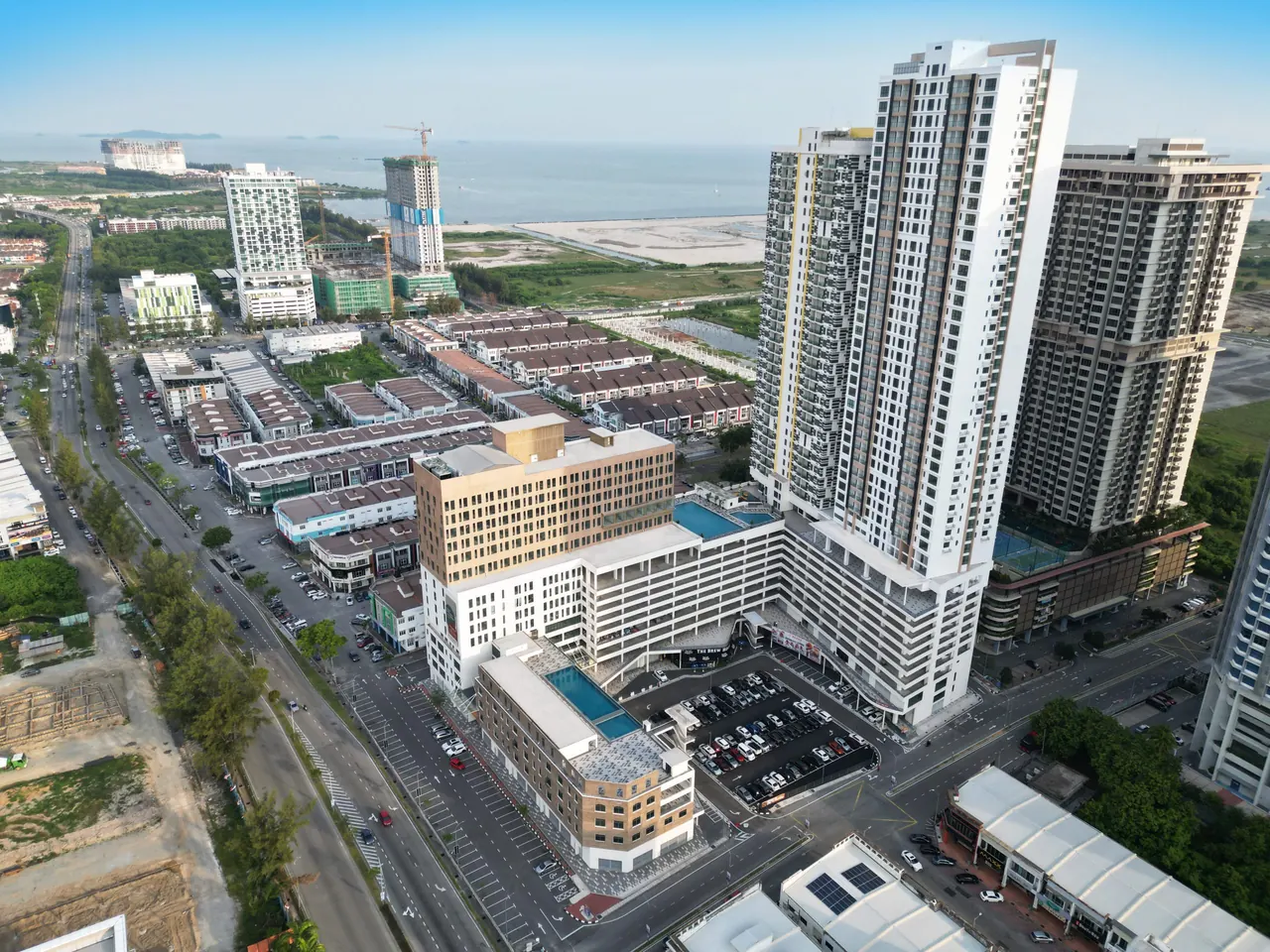 Aerial view over Asteria Melaka's towers with the Melaka coastline beyond.