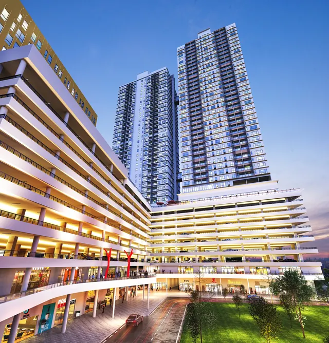 Asteria Melaka seen from below, its lit retail podium wrapping the tower base.